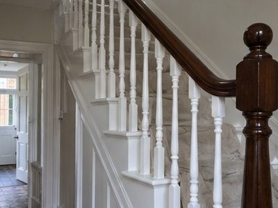 A finished staircase with white turned spindles and a dark varnished handrail